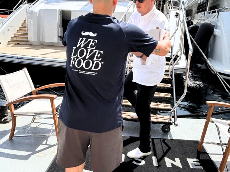 A Maison del Gusto team member handing a yacht provisioning box to a chef in Monaco